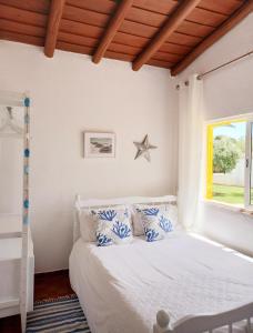 a bedroom with a bed with blue and white pillows at Villa Blue - Aldeia do Golfe in Quarteira