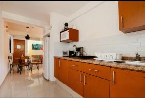 een keuken met houten kasten en een eetkamer bij Departamento en centro Cancún in Cancun