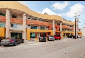 een groot gebouw met auto's ervoor geparkeerd bij Departamento en centro Cancún in Cancun