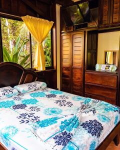 a bedroom with a bed with blue and white sheets and a window at FLOR DE PARAISO BUNGALOWS in Montezuma +248 photos