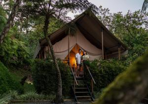 DariénGlamping Bellavista - Escapada Romántica en el Lago Calima的两人站在帐篷前