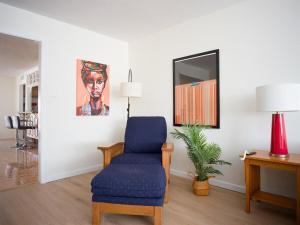 a living room with a blue chair and a mirror at Family Home, Pool, Pong, Nintendo in Simi Valley