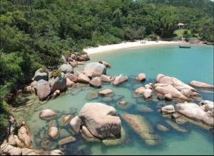 a large group of rocks in a body of water at Morada Som do Mar in Governador Celso Ramos