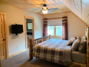ein Schlafzimmer mit einem Bett und einem Deckenventilator in der Unterkunft Ski Chalet btwn SundayRiver & MtAbram in Bethel