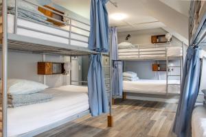 two bunk beds in a dorm room with blue drapes at Samesun Banff Hostel in Banff