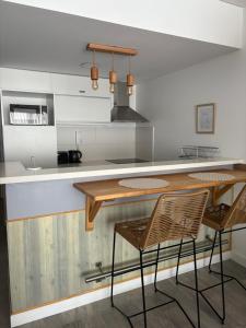 a kitchen with a counter with two chairs and a table at Moon House San Telmo in Buenos Aires