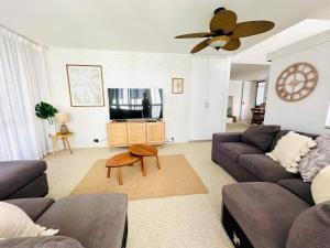 a living room with a couch and a ceiling fan at 3 bedrooms with Views over Kirra! in Gold Coast