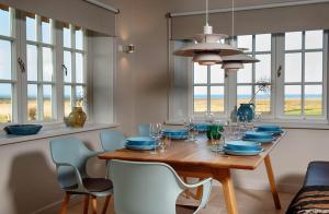 a dining room with a table and chairs and windows at LITZKOW 12808 in Westerwall