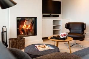 a living room with a fireplace and a chair at LITZKOW 12808 in Westerwall