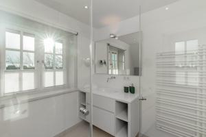 a white bathroom with a sink and a mirror at LITZKOW 12808 in Westerwall +23 photos