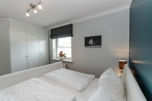 a bedroom with a white bed and a window at LITZKOW 11101 in Morsum