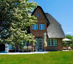 a large brick house with a thatched roof at LITZKOW 12808 in Westerwall