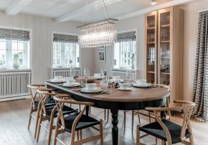 una sala da pranzo con tavolo, sedie e lampadario di LITZKOW 13301 a Westerwall