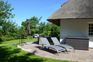 un gruppo di sedie e un ombrellone su un patio di LITZKOW 13301 a Westerwall