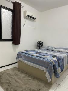 a bed in a white room with a window at Próx a praia in São Luís