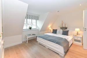 a bedroom with a large white bed and two windows at LITZKOW 12802 in Morsum