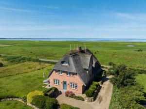 a large house with a thatched roof in a field at LITZKOW 12806 in Westerwall