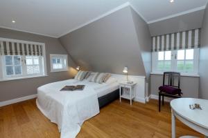 a bedroom with a bed and a table and windows at LITZKOW 12806 in Westerwall
