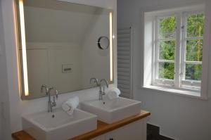 un bagno con due lavandini e un grande specchio di LITZKOW 16402 ad Archsum Altre 21 foto