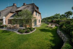 una casa con cortile dotato di tavolo e sedie di LITZKOW 16201 ad Archsum