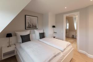 a large white bed in a room with a staircase at LITZKOW 16203 in Archsum