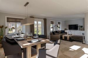 una sala da pranzo e un soggiorno con tavolo e sedie di LITZKOW 16205 ad Archsum