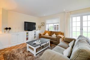 un soggiorno con due divani e una TV di LITZKOW 12503 a Morsum