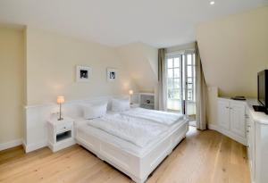 una camera da letto bianca con un letto e una finestra di LITZKOW 12503 a Morsum