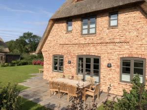 una casa in mattoni con tavolo e sedie nel cortile di LITZKOW 16205 ad Archsum