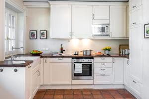 una cucina bianca con armadietti e elettrodomestici bianchi di LITZKOW 14204 a Morsum Altre 16 foto