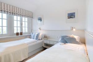 una camera da letto bianca con due letti e una finestra di LITZKOW 14204 a Morsum