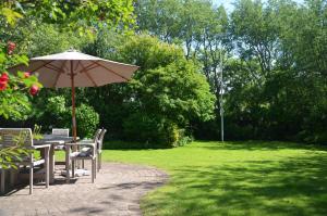 un tavolo e sedie con ombrellone in un parco di LITZKOW 14204 a Morsum