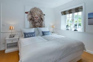 a bedroom with a bed with a picture of a sheep on the wall at LITZKOW 15001 in Morsum