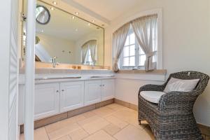a bathroom with a chair and a sink and a mirror at LITZKOW 15001 in Morsum +19 photos