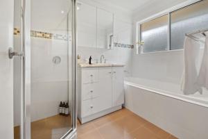 a white bathroom with a shower and a sink at Mountain Vista Retreat - Comfort Meets Style in Lake Albert +21 photos