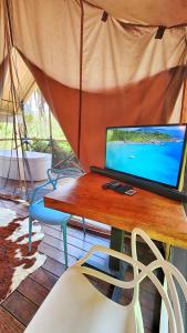 DariénGlamping Bellavista - Escapada Romántica en el Lago Calima的帐篷顶部的一张桌子和一台电脑