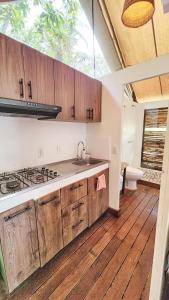 DariénGlamping Bellavista - Escapada Romántica en el Lago Calima的厨房配有木制橱柜、水槽和卫生间。