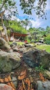 DariénGlamping Bellavista - Escapada Romántica en el Lago Calima的地面上的一群岩石,有一个凉亭 更多21张照片