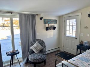 a bedroom with a bed and a chair and a window at Beach House - The Three Fish in Newport