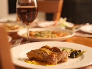 a plate of food on a table with a glass of wine at Pension Himawari in Iizuna