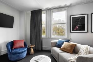 a living room with a couch and two chairs and a window at Veriu Central in Sydney