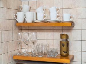 a shelf with glasses and cups and a coffee maker at Apartments Senjo - One Bedroom Apartment with Balcony with Sea View Apartman 1 in Cavtat +1 photo