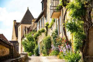 Une allée avec des fleurs sur le côté d'un bâtiment dans l'établissement Holiday Home in France with Private Terrace, à Mauroux