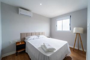 una camera da letto bianca con un letto e una finestra di AP 2Qtos, Garagem, Academia, Piscina, Wi-fi 500Mbp, Jr Catito a Brasilia