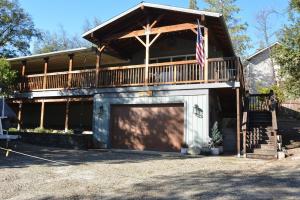 a house with a garage and an american flag at Ledge House-Lake Area in Bass Lake