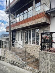 a brick house with stairs and a balcony at American House Filandia in Filandia