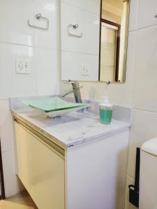un comptoir de salle de bain avec un lavabo et un miroir dans l'établissement Apartamento Expo Center Norte a 900 metros, à São Paulo