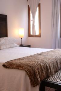 Un dormitorio con una cama con una manta marrón. en Hotel Iruya en Iruya