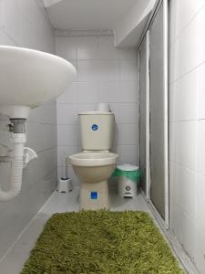 uma casa de banho com um WC, um lavatório e um tapete verde em Casa Familiar 4 Habitaciones con Agua Caliente, WiFi y Patio - Acepta Mascotas em Pereira