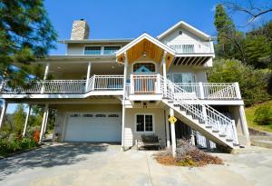 a large white house with a porch and stairs at Sierra Sunset Lake View in Bass Lake